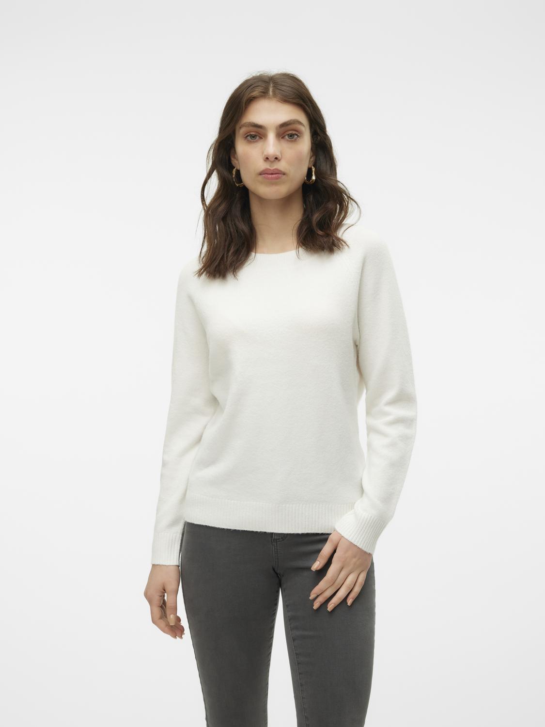 Woman wearing a white sweater and gray pants on a white background